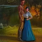 Man and woman in period clothing by forest river with waterfall and autumn foliage