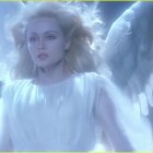 Blonde angel with white wings in soft blue glow