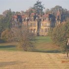 Illustration of Tudor-style house in autumn setting with intricate woodwork.