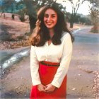 Smiling woman in white blouse and red skirt outdoors