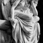 Monochrome angel sculpture with detailed wings and flowing robes