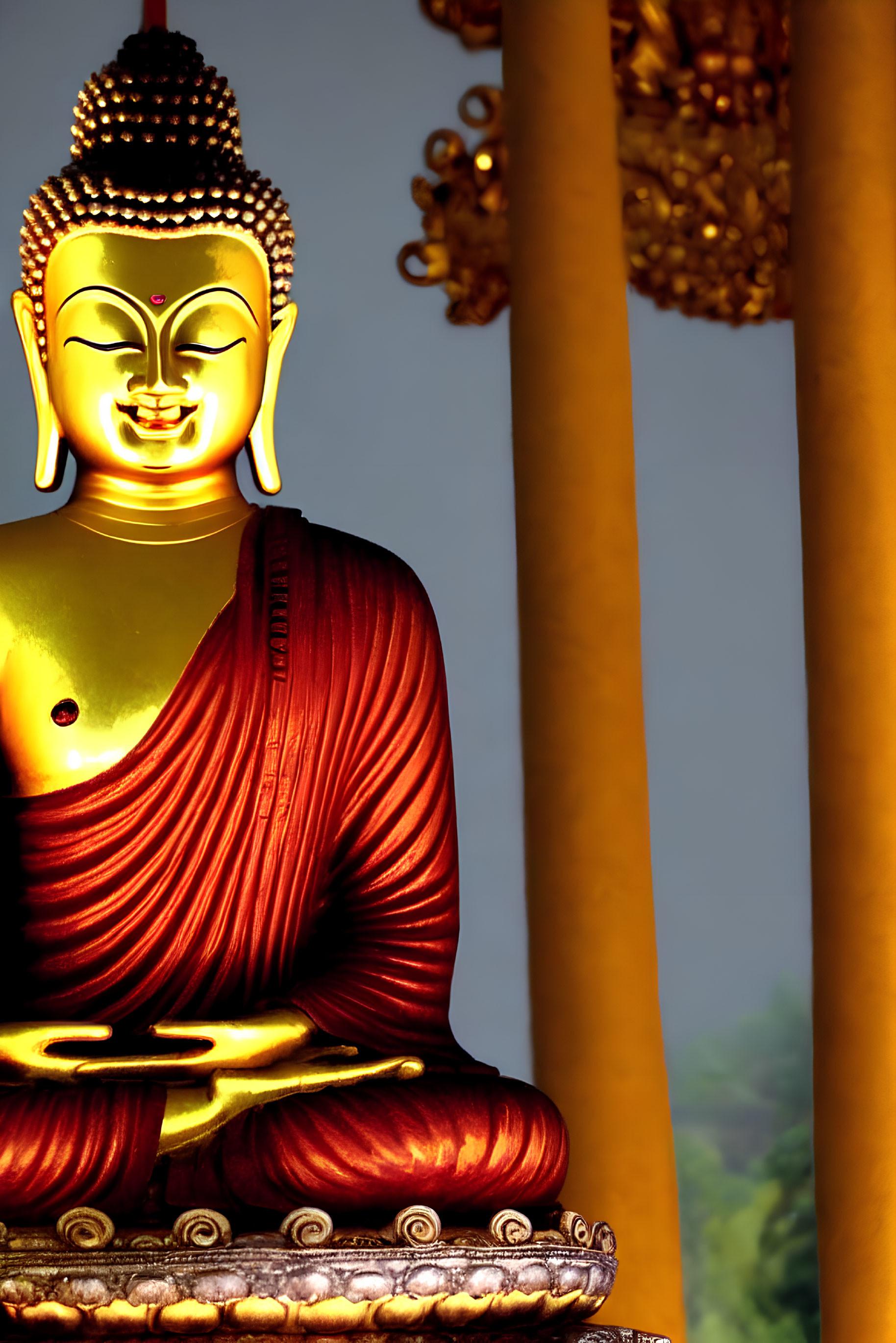 Golden Buddha statue in red robe with serene expression and golden pillars.