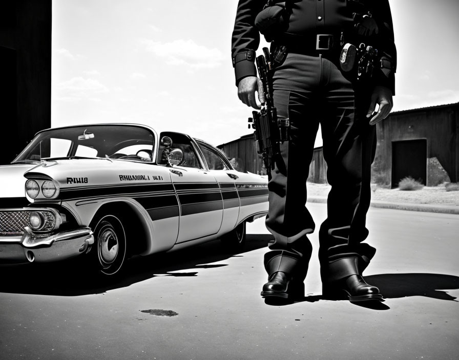 Vintage police officer next to patrol car in black and white photo