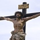 Robotic figure on crucifix under clear sky