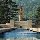 Tranquil garden fountain with three tiers and lush greenery