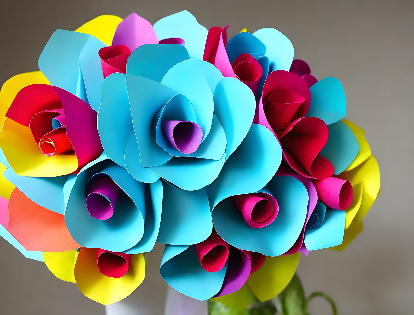 Vibrant paper flower bouquet in blue, pink, and yellow on grey background