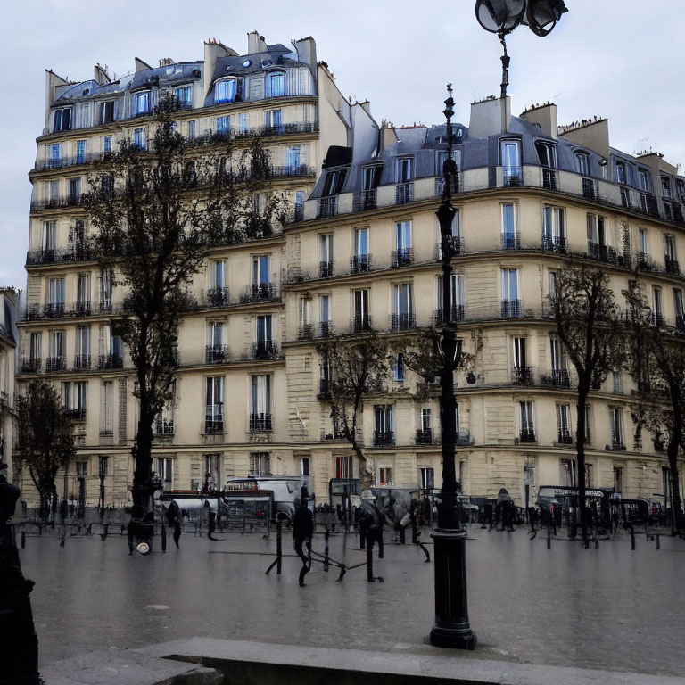 Parisian Haussmann-style buildings and street scene with people on wet pavement