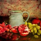 Ceramic jug, vibrant flowers, pomegranates, and blossoming branches in still life