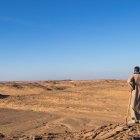 Vintage Attire Figure in Desert Landscape at Sunset