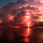 Dramatic desert landscape at dusk with lava flow and lightning strikes