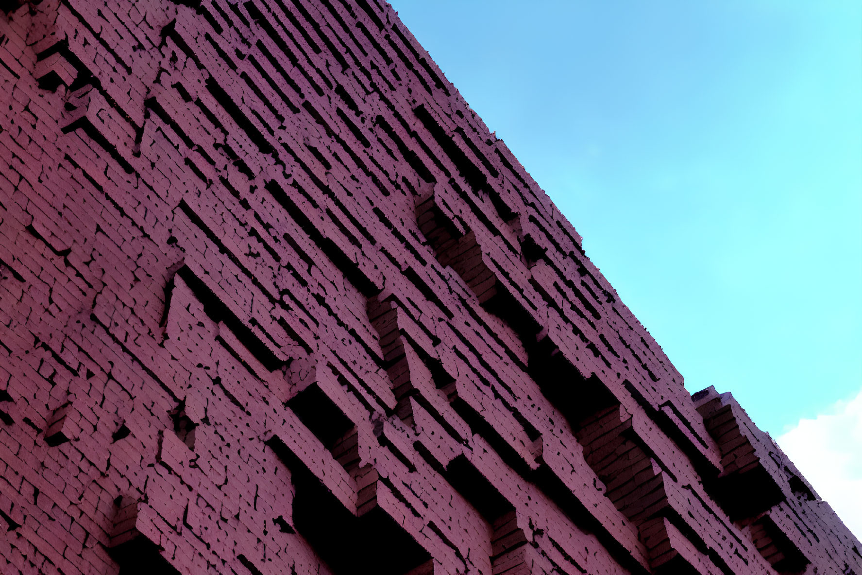 Geometric brick building facade under clear blue sky