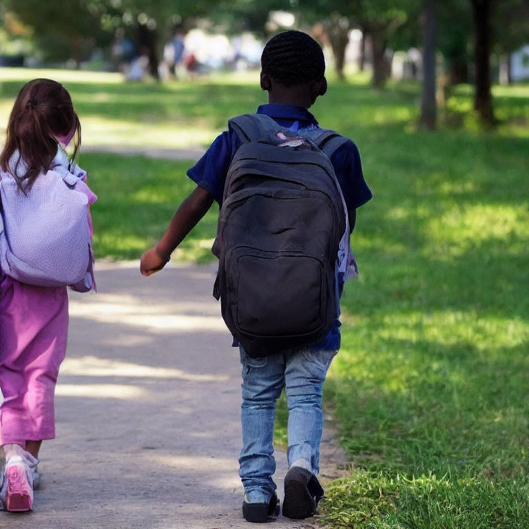 Children in pink and blue walking on park pathway