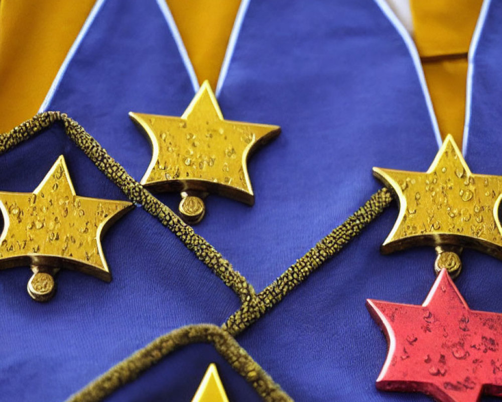 Shiny gold star-shaped medals on blue and yellow ribbon with water droplets