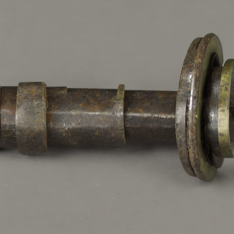 Corroded metal shaft with flanged end in close-up view