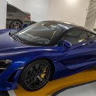 Luxury blue sports convertible in modern garage with other high-end cars