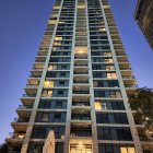 Tall building harmonizing with nature, arched doorways, large windows, ivy, twilight