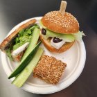 Vibrant plate with sandwich, veggies, lime, grilled fruit & seasoning