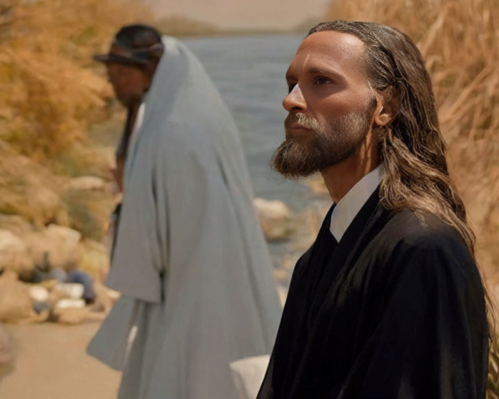 Two men in historical robes by riverbank, one facing camera, other walking away