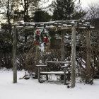 Snowy Winter Scene with Festive Pergola and Christmas Trees