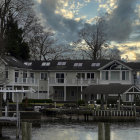 Tranquil beachfront with resort buildings, forest, and golden sunset