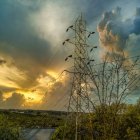 Traditional tower in lush foliage under dramatic sunset sky