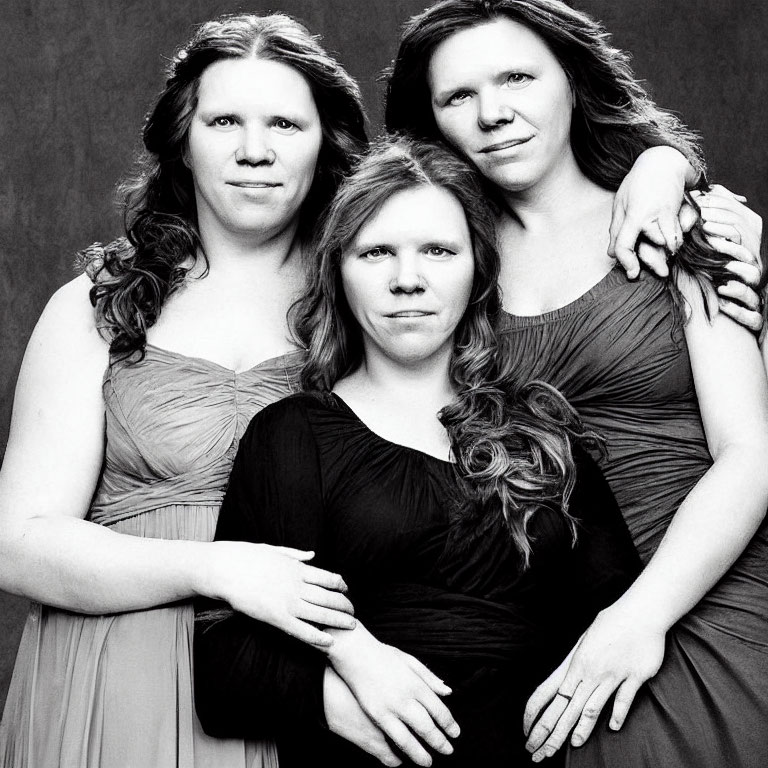 Three Women Posing in Semi-Formal Dresses on Dark Background