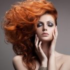 Red-haired woman with green eyes and golden bracelet portrait.