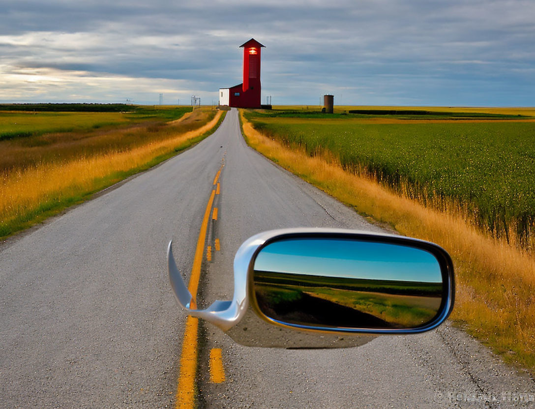 Open road towards red structure under cloudy sky with car's mirror reflection