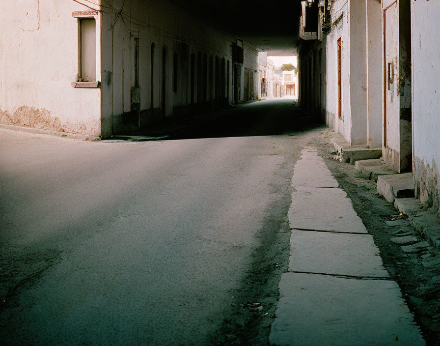 Empty Urban Street with Buildings and Shadows at Dawn or Dusk