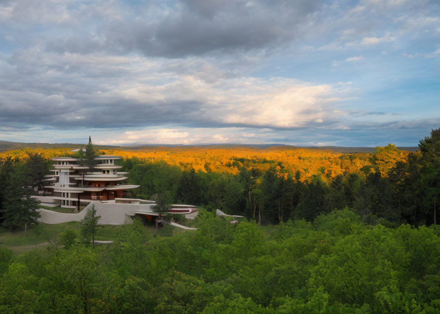 Modern multi-level building in lush autumn forest under dramatic sky