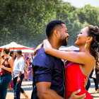 Couple dancing closely at outdoor event with sparkling lights