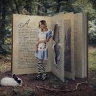 Person in Forest Between Large Open Book Pages