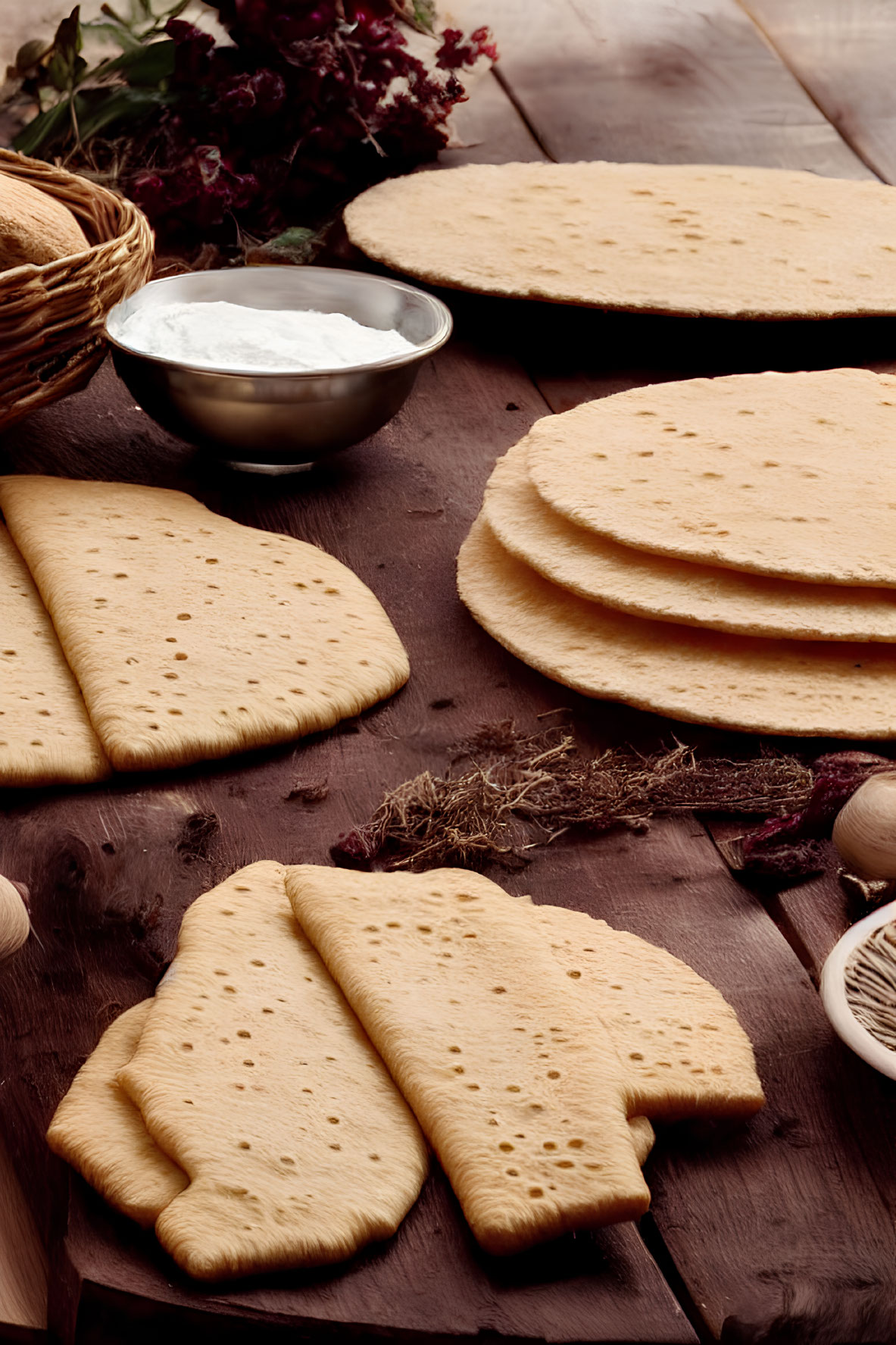 Assorted flatbreads, yogurt, and herbs on wooden surface