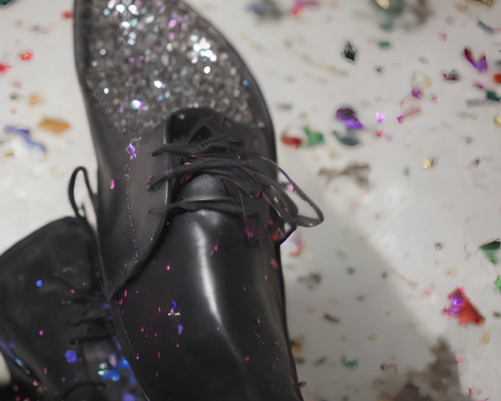 Black Dress Shoes with Glittery Detailing on Confetti-Covered Surface
