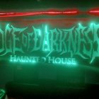 Eerie Green and Red Lighting Surrounding Stylized "Frightmare Haunted House" Sign