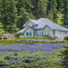 Whimsical blue house in lush greenery with intricate trees and calm water.