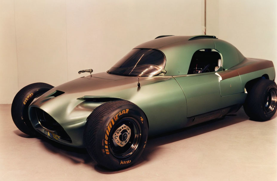 Vintage Green Race Car with Streamlined Design and Black Racing Tires