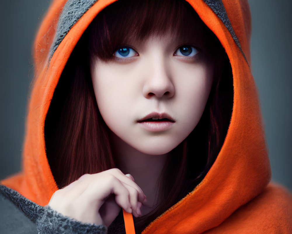 Blue-eyed person in orange hooded garment with grey lining