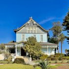 Colorful Watercolor Painting of Two-Story Blue House with Red Roof