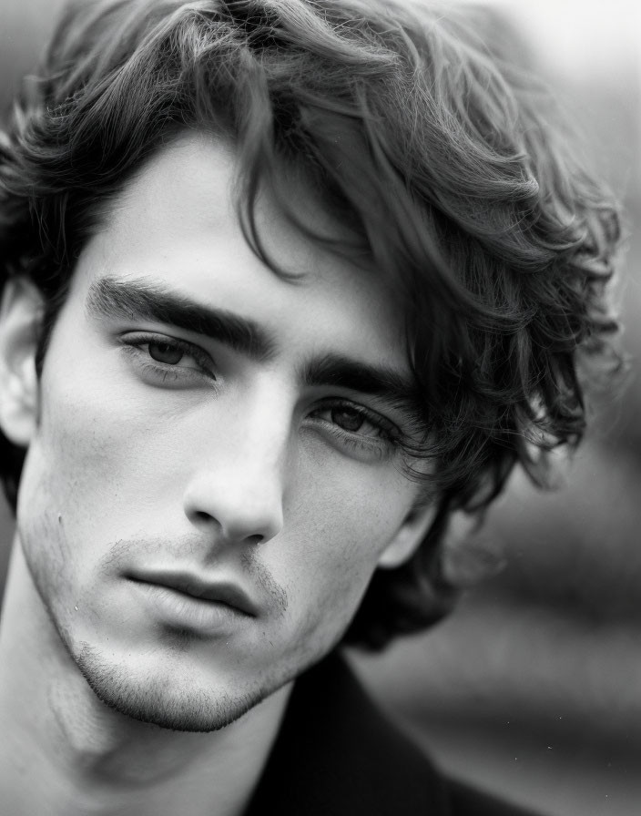 Monochrome portrait of a young man with tousled curly hair