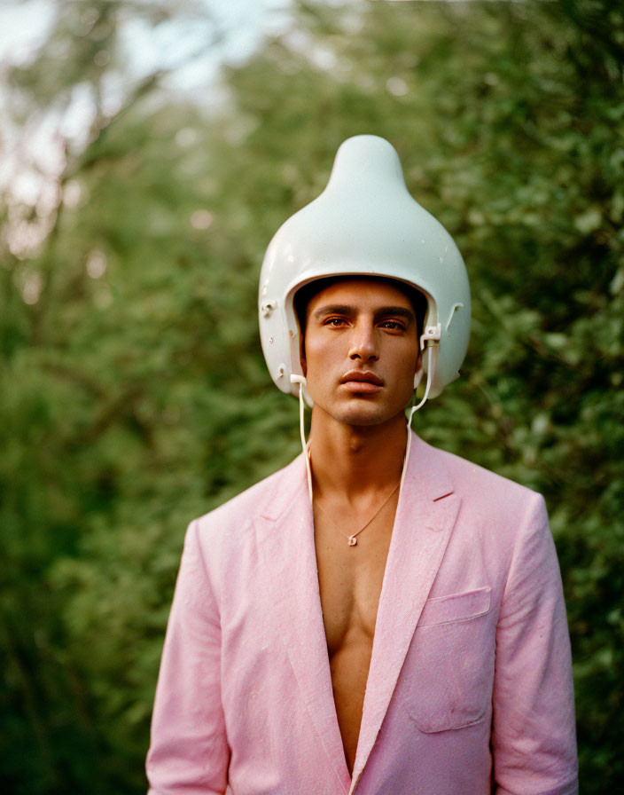 Man in Pink Suit Jacket with White Helmet in Greenery Background