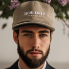 Man with piercing blue eyes wearing floral crown of pink blossoms.