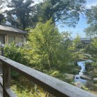 Woman in kimono on wooden balcony overlooking serene Japanese garden