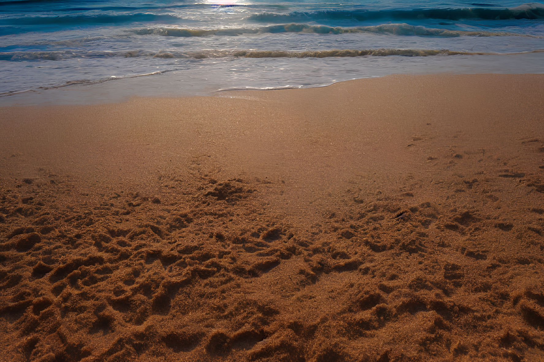 Scenic golden sandy beach with blue waves and clear sky