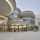 Ornate multi-story building with modern glass extension in snowy twilight landscape