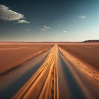 Tranquil desert landscape: straight road, rolling sand dunes, sunset sky