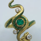 3D-rendered image of coiled jeweled snake with emerald scales and gold details