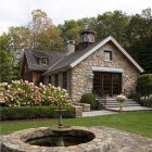 Stone house with pitched roof and well in garden