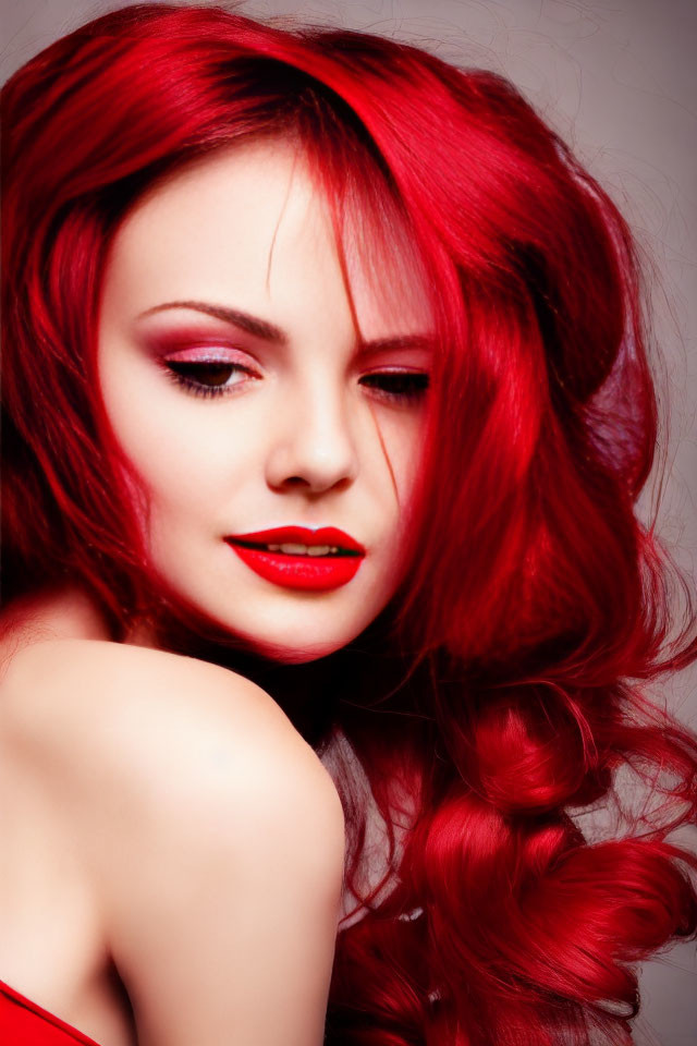 Woman with Vibrant Red Hair and Lipstick Posing Against Red Backdrop