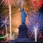 Night sky fireworks display behind Statue of Liberty